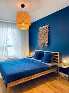 格但斯克Apartament z Widokiem na Morze的蓝色的卧室,配有床和蓝色的墙壁