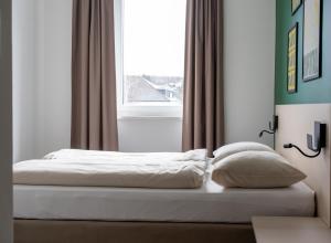 林茨SLEEEP HOTEL Ansfelden的卧室内的一张床位,带窗户