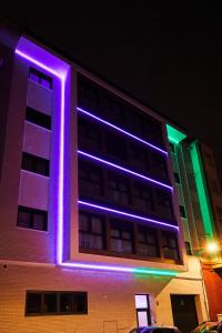 卡斯特利翁-德拉普拉纳RIBALTA SENSACIONES的一座紫色和绿灯的建筑