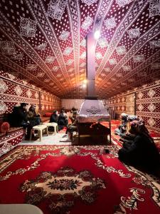 瓦迪拉姆Wadi Rum Quiet Village Camp的一间拥有红色和白色图案的墙壁的房间