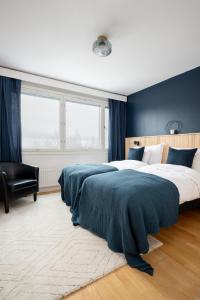 库奥皮奥2 Bedroom apartment with free parking的一间卧室配有一张带蓝色墙壁的大床
