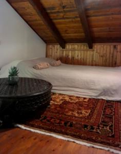 埃普塔罗弗斯Petradi Residence @ Agoriani-Parnassus的卧室配有床和桌子,铺在地毯上