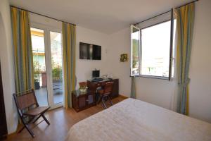 德瓦玛丽娜克蕾丽雅酒店的一间卧室配有一张床、一张书桌和一个窗户。