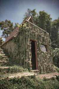 PujunganKAMPUNG KOPI CAMP的一座小石头建筑,上面有棕榈树