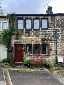 海伯敦桥Charming 2-Bed Cottage in Hebden Bridge的前面有红长凳的砖砌建筑