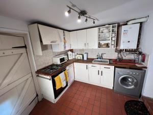 海伯敦桥Charming 2-Bed Cottage in Hebden Bridge的厨房配有白色橱柜和炉灶烤箱。