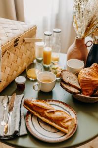 波尔多B&B Maison Rosa的桌子上放有面包、咖啡和烤面包