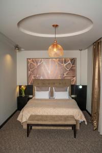 贝尔格莱德Akacija Luxury Suites的一间卧室配有一张大床,内有长凳