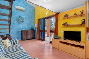帕劳Gli Ulivi Palau - La Zirichelta的客厅设有黄色的墙壁和平面电视。