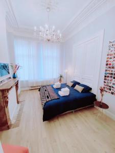 安特卫普CoCo Romantic - apartment in most trendy central hotspot of Antwerp的一间卧室配有一张大床和一架钢琴