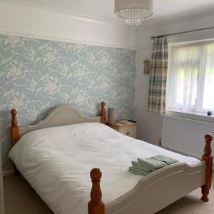 莱姆里吉斯Nettle Bank的一间卧室配有一张蓝色花卉壁纸床