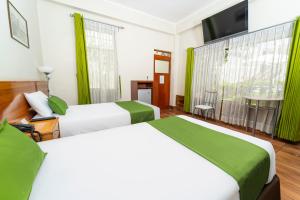 阿雷基帕Hotel El Turista的酒店客房设有两张床和一台平面电视。
