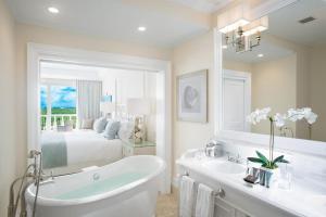 格雷斯湾特克斯和凯科斯群岛海岸俱乐部度假村的带浴缸的浴室和1间带1张床的卧室