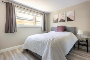 基奇纳ENTIRE 2 BEDROOM APARTMENT DOWNTOWN - u2的卧室配有白色的床和窗户。