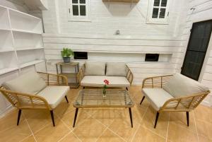 Ban Sa LaWhitehouse cafe&Guesthouse的庭院配有两把椅子、一张桌子和一张沙发
