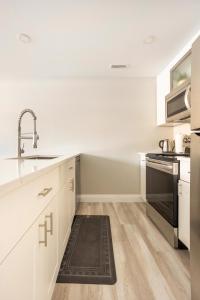 基奇纳ENTIRE 2 BEDROOM APARTMENT DOWNTOWN - u1的厨房配有白色橱柜、水槽和炉灶。