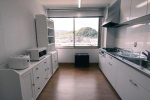 舞鹤市Manabiamu 4F - Vacation STAY 58913v的一间厨房,配有白色的橱柜和大窗户