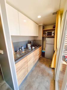 比奥格勒·纳·莫鲁Bungalow Home Sweet Home - Logement complet的一间带水槽和冰箱的小厨房