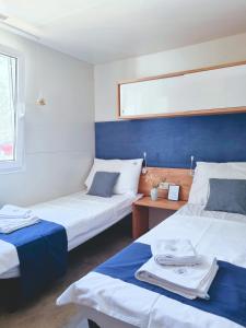 比奥格勒·纳·莫鲁Bungalow Home Sweet Home - Logement complet的客房设有两张床和一张带毛巾的桌子。