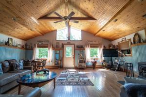 RoscoeRoscoe Cabin Pet friendly的客厅设有木制天花板和吊扇
