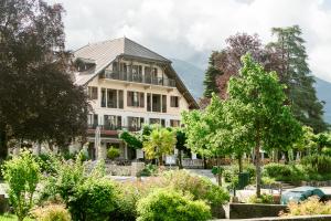 塔卢瓦尔Hotel Le Cottage Bise的前面设有花园的大房子