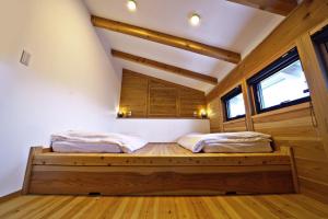 饭山市Tombi Lodge - Vacation STAY 14464v的客房内设有两张床,铺有木地板,设有窗户。
