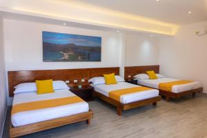 阿约拉港Hotel Las Ninfas的酒店客房 - 带两张带黄色枕头的床