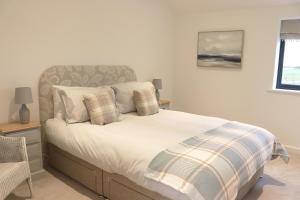 白金汉Cowley Farm, Preston Bissett, Buckingham的一间卧室配有带白色床单和枕头的床。