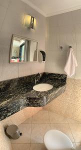 陶巴特由你达德巴罗保帕酒店的一间带水槽和镜子的浴室