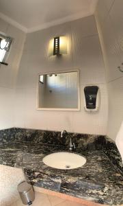 陶巴特由你达德巴罗保帕酒店的一间带水槽和镜子的浴室