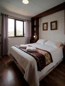 昆卡昆卡厄瓜多尔奥拓罗格公寓式酒店的一间卧室设有一张大床和一个窗户。