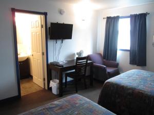 TeslinNisutlin Trading Post Motel的酒店客房配有书桌和椅子