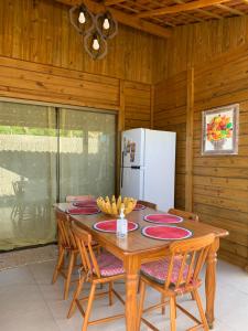 安谢塔Pousada Portal da Praia的餐桌、椅子和白色冰箱