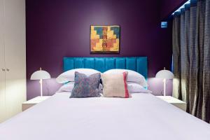 利马✶ Maras Residence ✶ LUXURY Rooftop Pool & Grill的卧室配有一张白色大床和紫色墙壁