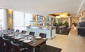 悉尼帕拉马塔假日酒店的一间带长桌和椅子的用餐室