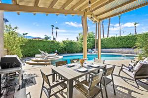 棕榈泉California Dreamin'的一个带桌椅的庭院和一个游泳池