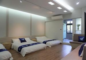 公馆藴慢築 茶花藝主題民宿 Yun Man Zhu Homestay的一间设有两张床和一张沙发的房间