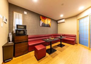 东京YADOYA 夢路的客厅配有红色沙发和电视
