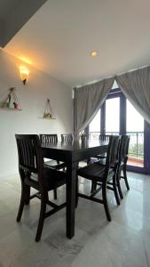 瓜埠Sugar Marina Seaview Families Suite Apartment的一间用餐室,配有一张黑桌子和两把椅子