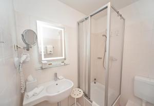 萨勒河畔哈雷City-Hotel Am Wasserturm Halle的白色的浴室设有水槽和淋浴。