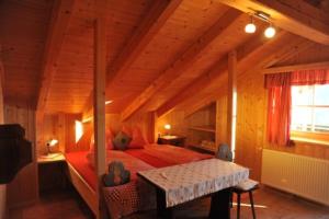 圣莱奥纳尔多因帕西里亚Almgasthaus Flecknerhütte的木制客房内的一间卧室,配有一张床
