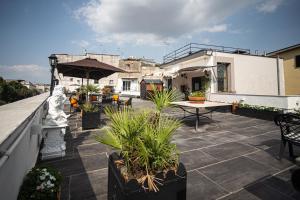 那不勒斯德利亚罗托布他尼科酒店的一个带盆栽植物和一张桌子的庭院