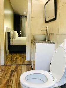 约翰内斯堡天使旅馆的浴室配有白色卫生间和盥洗盆。