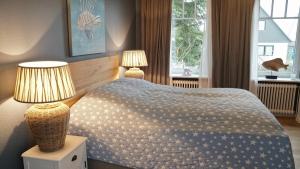 SchaalbyMaries Haus的一间卧室配有一张带两盏灯的床和一扇窗户。