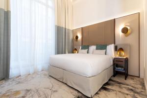 巴黎InterContinental Paris Champs Elysées Etoile, an IHG Hotel的卧室设有一张白色大床和一扇窗户。