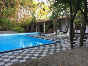 锡吉里亚AliKele Hotel & Resort的一个带 ⁇ 板和椅子的游泳池以及一座房子