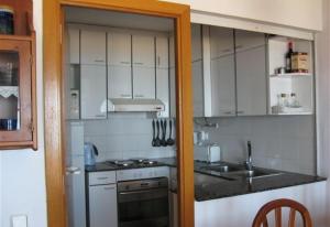 阿尔塔夫拉Baywatch Penthouse的厨房配有白色橱柜、水槽和炉灶。