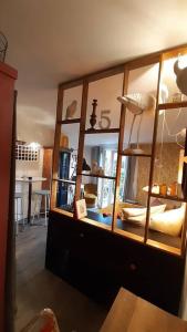 塔朗斯Sauveur le Sculpteur的客房设有带玻璃门的大型木制橱柜。