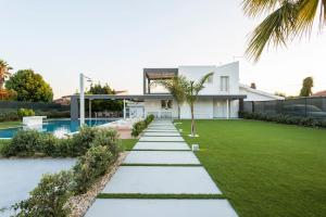 科米索Villa Zoe的一座带草坪和游泳池的房子
