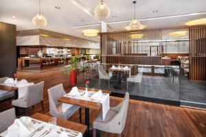 莱奥本Asia Hotel & Spa Leoben的一间带桌椅的餐厅和一间酒吧